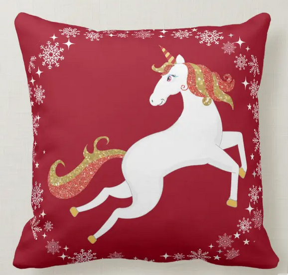Christmas pillow with a magical unicorn with red and golden glitter in his mane and tail, and with a circle of snowflakes