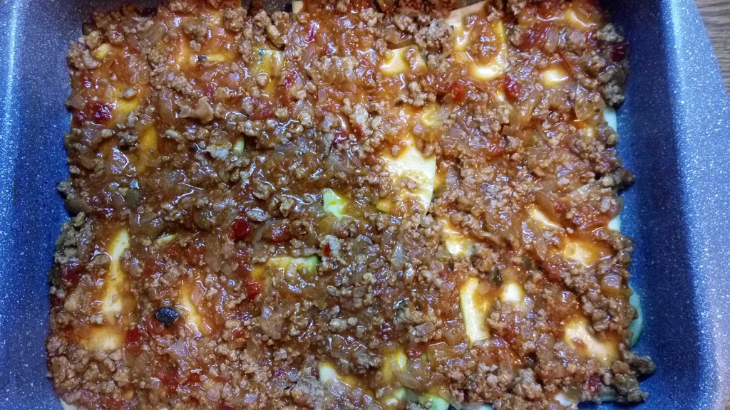 Adding half the meat mix on top of the zucchini slices