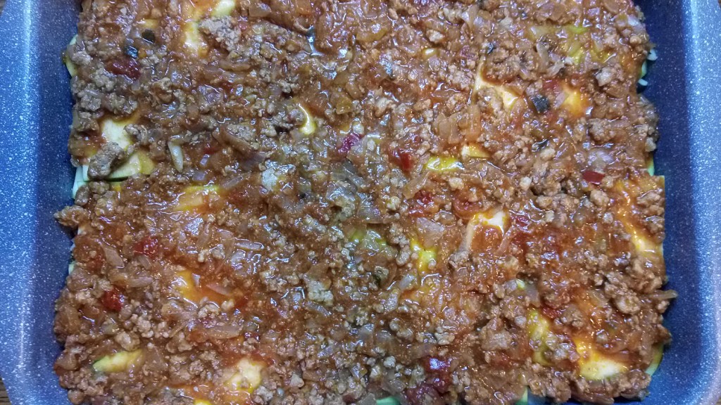 Adding the second half of the meat mix in the zucchini lasagna