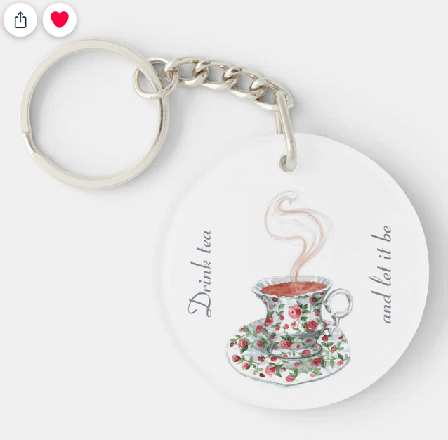 Elegant single-sided keychain with an illustration of a vintage tea cup and saucer with red roses and the popular tea slogan "Drink tea and let it be"