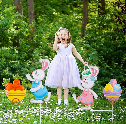 Metal yard decoration for Easter with a boy and girl bunny rabbits on stakes, with a basket of carrots and one of decorated eggs