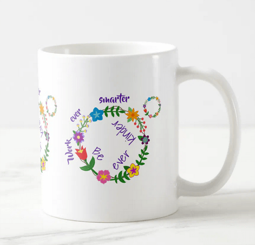 Scatter kindness by working smarter and becoming kinder in the process. Coffee mug with an illustration of a circle of colorful spring flowers that then is replicated in the heart of another person