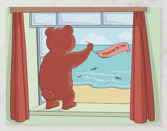 Postcard with a cute teddy bear looking out the window (to a beach scene with birds flying over the water) and holding a "Thinking of you" banner