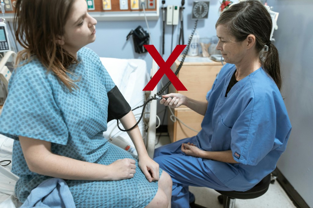 A nurse checking a woman's BP (incorrectly) in a hospital setting