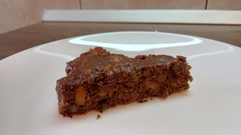 A piece of vegan chocolate banana cake with dried fruits