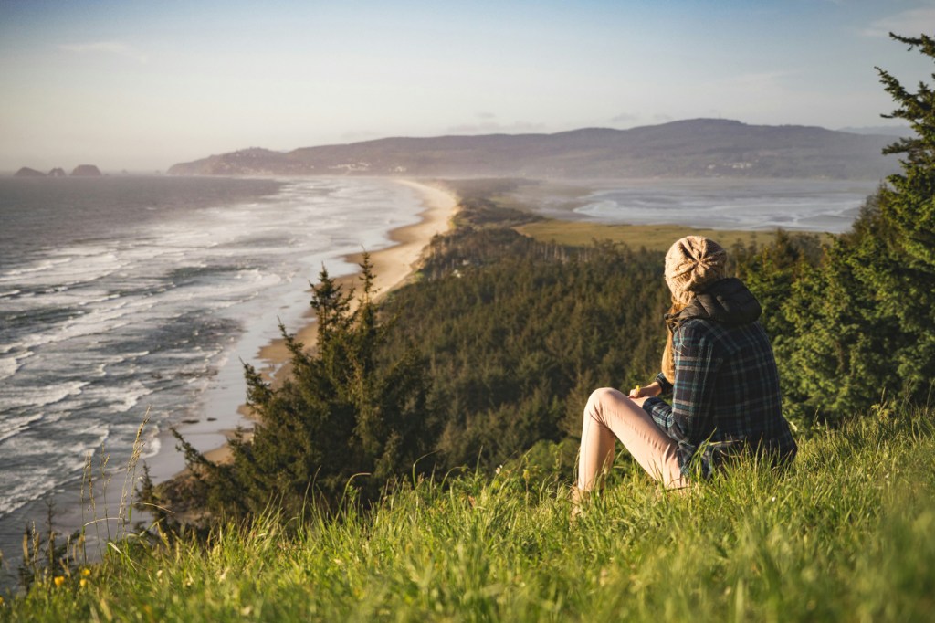Woman on a mound of earth by the beach