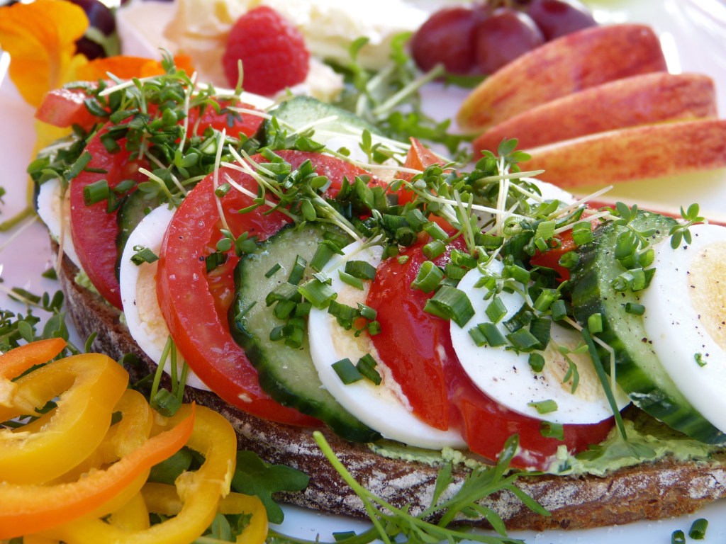 Bread with slices of tomatoes, cucumbers, and eggs, and other healthy breakfast foods