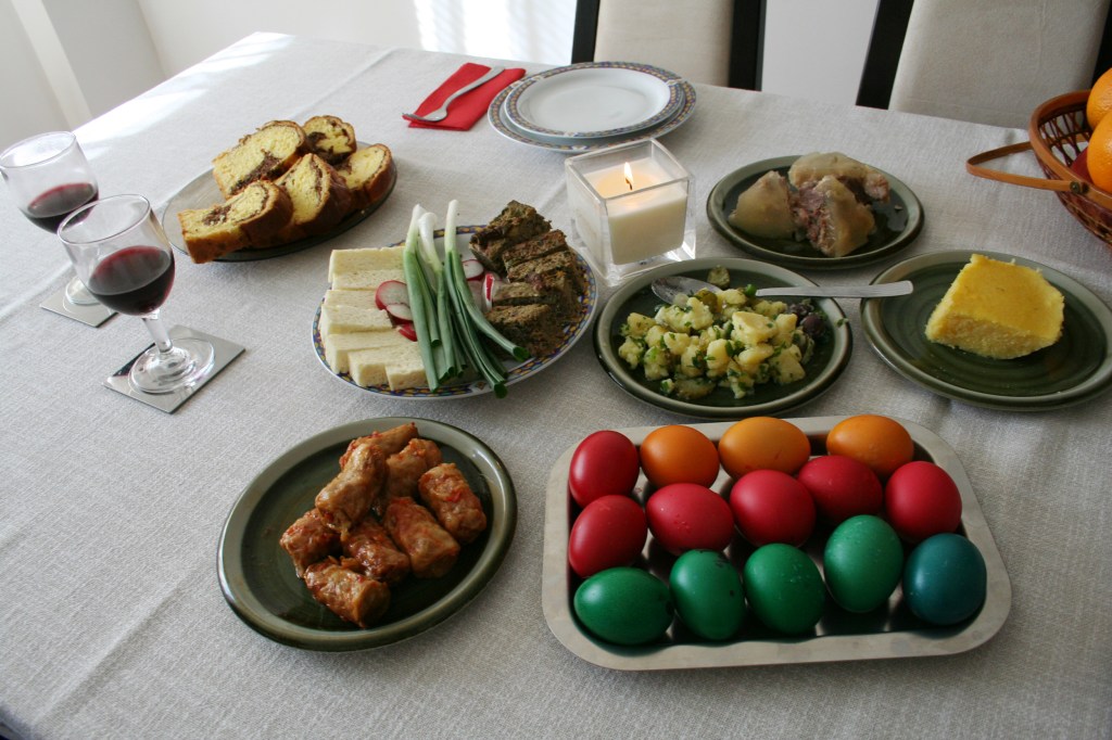An Easter feast. Easter foods on a table, including dyed eggs, sarmale, drob de miel, cozonac, and other dishes