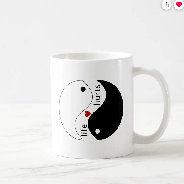 Coffee mug with the inspirational slogan "life hurts" and a heart, with the yin-yang symbol